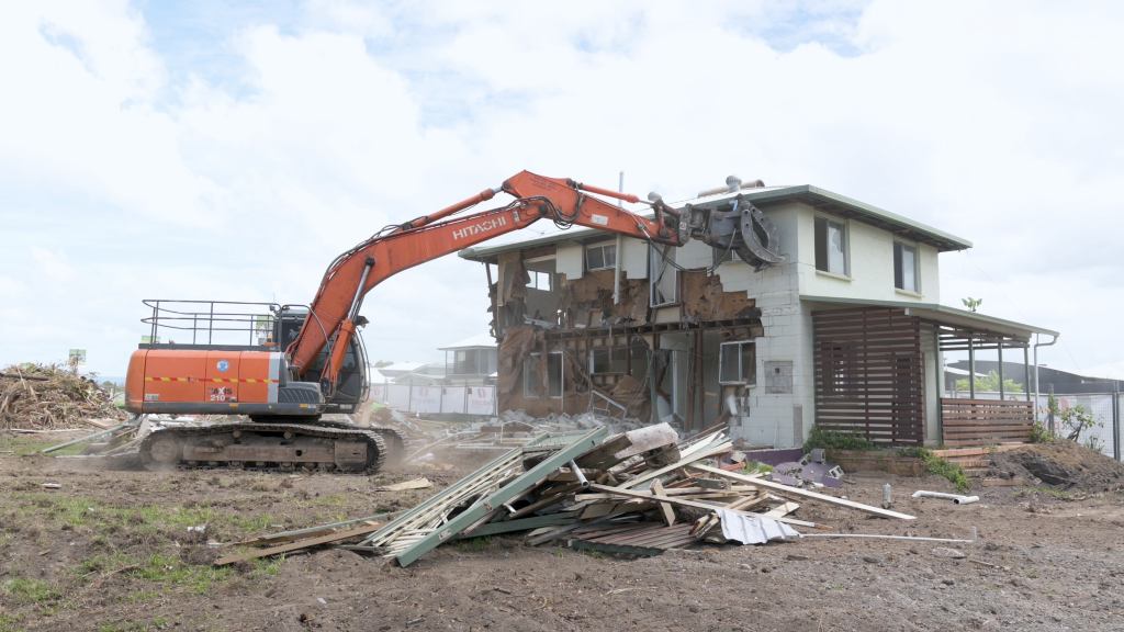 excavator knocking down residential property